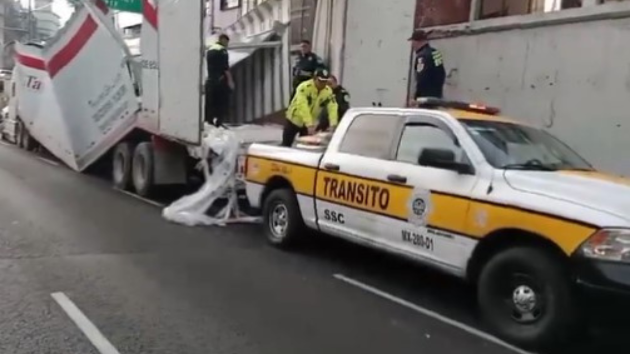 Tráiler queda atorado en puente; su caja queda destruida con 22 toneladas de arena para gato